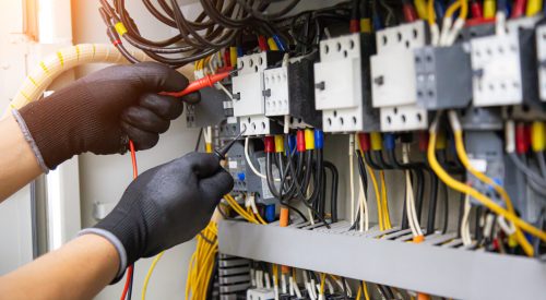 Electrical technician hand checking electricity circuit breaker main power on switchboard cabinet for service maintenance and electric cable wiring check for safety concepts.